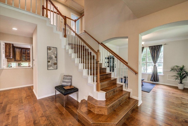 10601 Queensbury Cv, Austin, TX 78726 - stairway with arched walkways, hardwood / wood-style floors, and ornamental molding