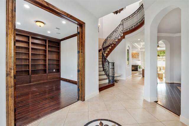 107 Bella Strada Cv, Lakeway, TX 78734 - foyer featuring ornamental molding, arched walkways, light tile patterned floors, stairway, and recessed lighting