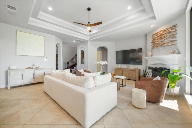 107 Bella Strada Cv, Lakeway, TX 78734 - living area with arched walkways, a raised ceiling, stairs, light tile patterned floors, and recessed lighting