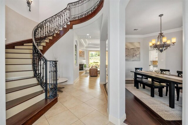 107 Bella Strada Cv, Lakeway, TX 78734 - foyer entrance with stairs, a chandelier, crown molding, tile patterned flooring, and recessed lighting