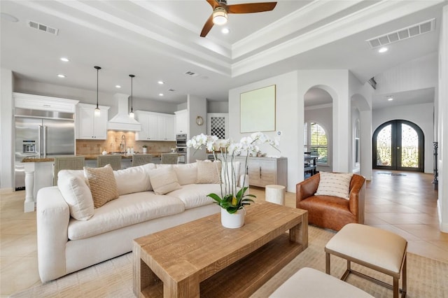 107 Bella Strada Cv, Lakeway, TX 78734 - living room featuring arched walkways, light tile patterned floors, recessed lighting, a raised ceiling, and a ceiling fan