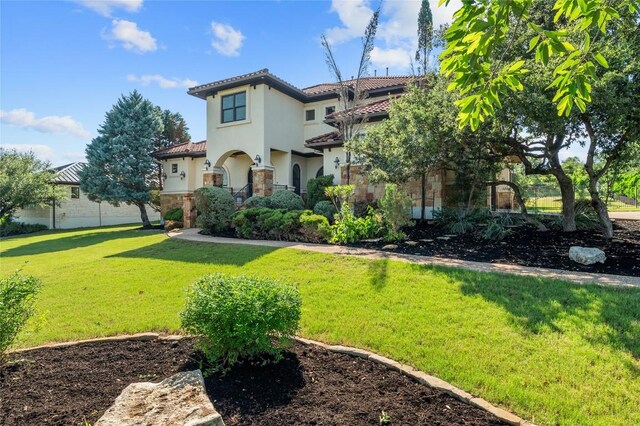 107 Bella Strada Cv, Lakeway, TX 78734 - mediterranean / spanish house with a tile roof, a front lawn, stucco siding, and stone siding