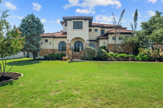 107 Bella Strada Cv, Lakeway, TX 78734 - mediterranean / spanish-style house featuring stone siding, a front lawn, and a tile roof