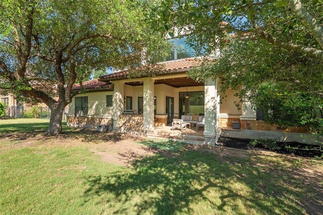107 Bella Strada Cv, Lakeway, TX 78734 - rear view of house with a lawn, a tile roof, and stucco siding