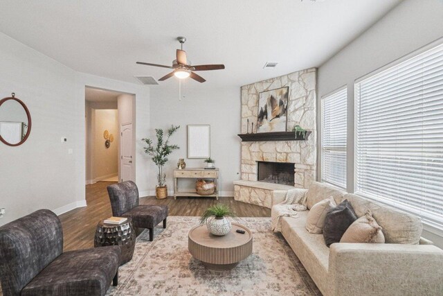 113 Berkeley Pl, Georgetown, TX 78628 - living room with wood finished floors, a ceiling fan, and a stone fireplace