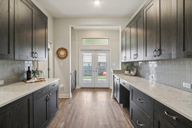 113 Berkeley Pl, Georgetown, TX 78628 - kitchen with tasteful backsplash, light wood finished floors, light stone counters, and french doors