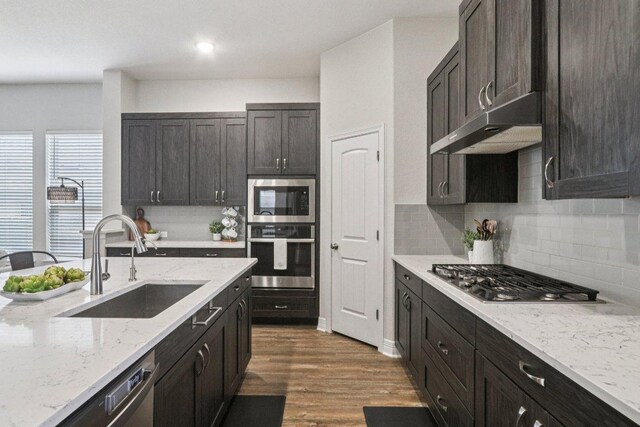 113 Berkeley Pl, Georgetown, TX 78628 - kitchen featuring stainless steel appliances, under cabinet range hood, tasteful backsplash, dark wood-type flooring, and light stone counters