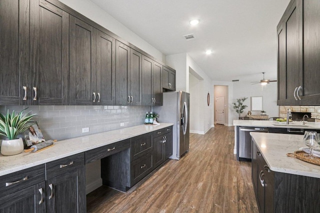 113 Berkeley Pl, Georgetown, TX 78628 - kitchen with appliances with stainless steel finishes, backsplash, dark wood-style floors, ceiling fan, and light stone counters
