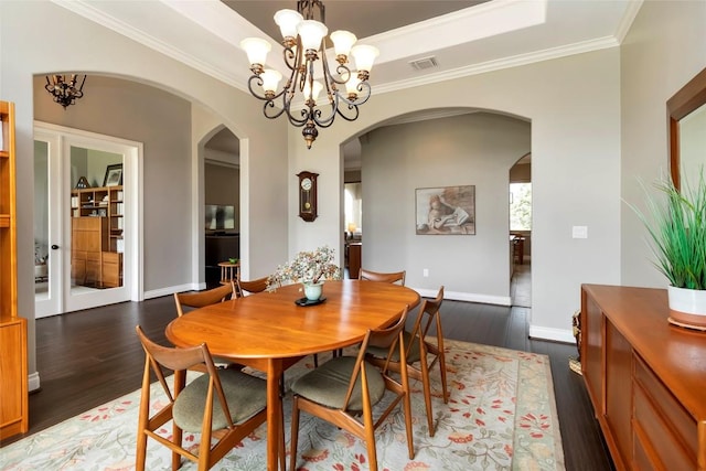 106 Packsaddle Dr, Bastrop, TX 78602 - dining room with arched walkways, dark wood finished floors, crown molding, and a chandelier
