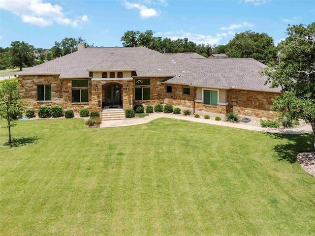 106 Packsaddle Dr, Bastrop, TX 78602 - view of front of house with a chimney, a front yard, french doors, and stone siding
