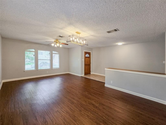 1318 Chalk Ln, Cedar Park, TX 78613 - empty room featuring dark wood-type flooring, ceiling fan, a textured ceiling, and a chandelier