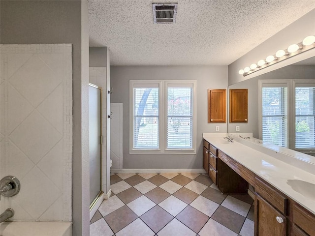 1318 Chalk Ln, Cedar Park, TX 78613 - full bathroom with a shower stall, a textured ceiling, double vanity, healthy amount of natural light, and tile patterned flooring