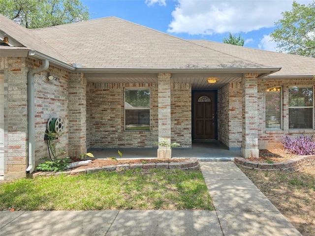 1318 Chalk Ln, Cedar Park, TX 78613 - doorway to property with covered porch, roof with shingles, and brick siding