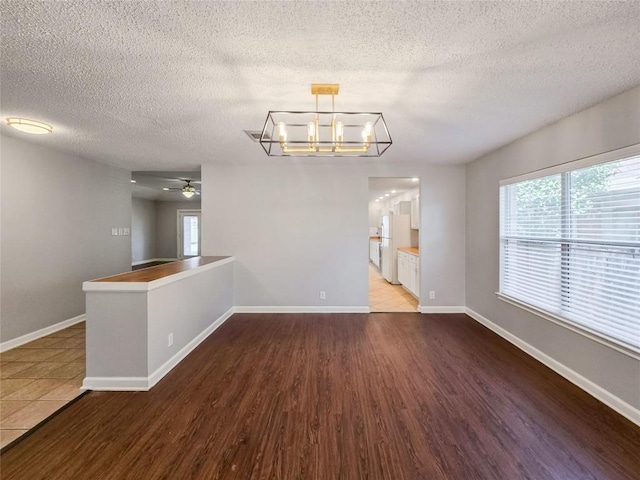 1318 Chalk Ln, Cedar Park, TX 78613 - unfurnished dining area with ceiling fan, wood finished floors, a textured ceiling, and a chandelier