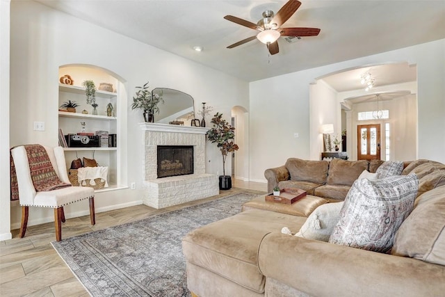 4304 Lost Oasis Holw, Austin, TX 78739 - living area with arched walkways, ceiling fan, built in shelves, and a fireplace