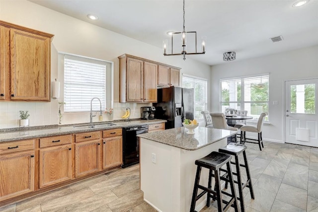 4304 Lost Oasis Holw, Austin, TX 78739 - kitchen featuring black appliances, backsplash, light stone countertops, a breakfast bar area, and a center island