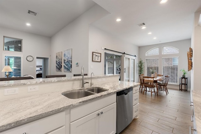 624 Judge Fisk Dr, Leander, TX 78641 - kitchen with stainless steel dishwasher, recessed lighting, light wood-type flooring, white cabinets, and light stone countertops
