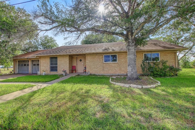 1402 Herder Ave, Schulenburg, TX 78956 - ranch-style house featuring a front yard, asphalt driveway, a garage, and brick siding
