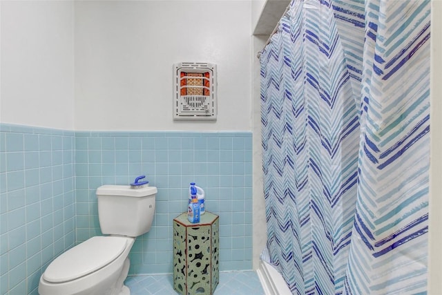 1402 Herder Ave, Schulenburg, TX 78956 - bathroom featuring a shower with curtain, tile walls, and a wainscoted wall