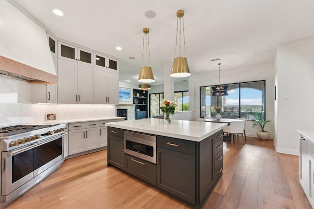 1108 Lakewood Hills Ter, Austin, TX 78732 - kitchen with stainless steel appliances, light countertops, custom exhaust hood, white cabinetry, and recessed lighting