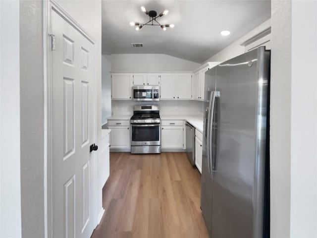 1207 Brashear Ln, Cedar Park, TX 78613 - kitchen with appliances with stainless steel finishes, lofted ceiling, light wood-style floors, white cabinetry, and light countertops