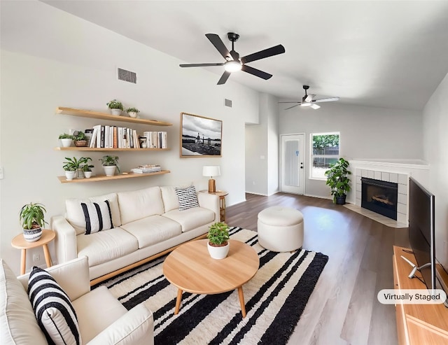 1207 Brashear Ln, Cedar Park, TX 78613 - living room with wood finished floors, a ceiling fan, a tile fireplace, and vaulted ceiling