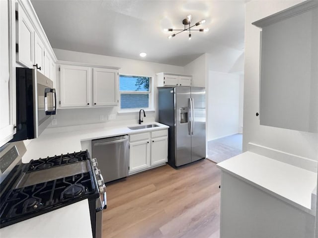 1207 Brashear Ln, Cedar Park, TX 78613 - kitchen with appliances with stainless steel finishes, light wood-style flooring, white cabinets, and light countertops