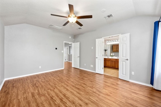8701 Meridian Oak Ln, Austin, TX 78744 - unfurnished bedroom featuring lofted ceiling, light wood finished floors, connected bathroom, and ceiling fan