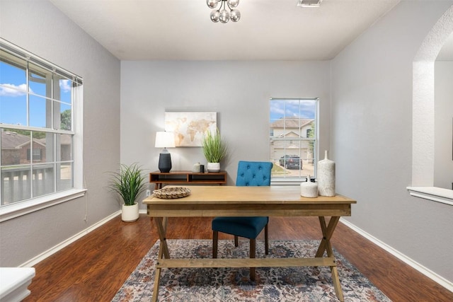 8701 Meridian Oak Ln, Austin, TX 78744 - home office featuring arched walkways, wood finished floors, and a chandelier