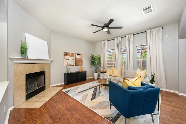 8701 Meridian Oak Ln, Austin, TX 78744 - living area featuring ceiling fan, wood finished floors, and a tile fireplace