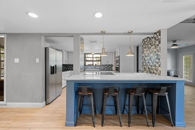 6110 Gardenridge Holw, Austin, TX 78750 - kitchen with stainless steel appliances, tasteful backsplash, a breakfast bar area, light wood-type flooring, and a ceiling fan