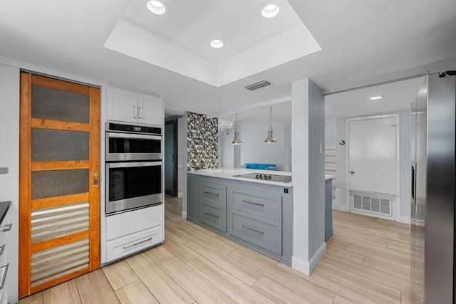 6110 Gardenridge Holw, Austin, TX 78750 - kitchen with double oven, a raised ceiling, light wood-style flooring, light countertops, and recessed lighting