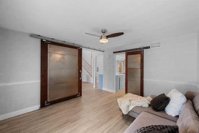 6110 Gardenridge Holw, Austin, TX 78750 - living area featuring a barn door, light wood-style flooring, and ceiling fan