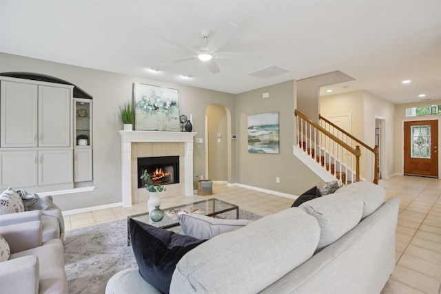 6520 Walebridge Ln, Austin, TX 78739 - living area with light tile patterned flooring, stairway, ceiling fan, arched walkways, and a tiled fireplace