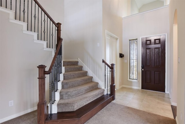 19908 Eire Dr, Pflugerville, TX 78660 - entryway featuring a high ceiling, carpet, stairs, arched walkways, and tile patterned flooring