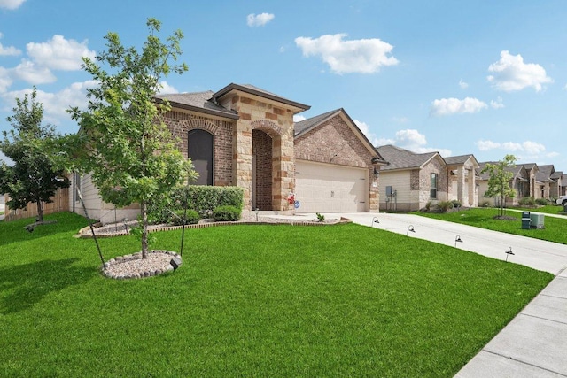 184 Pivot Dr, Taylor, TX 76574 - view of front facade with stone siding, a front lawn, driveway, and an attached garage