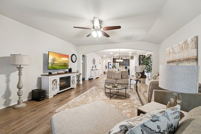 184 Pivot Dr, Taylor, TX 76574 - living area with arched walkways, ceiling fan, wood finished floors, and a chandelier