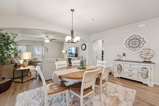 184 Pivot Dr, Taylor, TX 76574 - dining space featuring arched walkways, vaulted ceiling, ceiling fan, light wood-style flooring, and a chandelier
