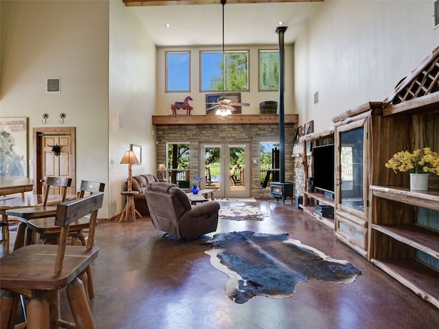 762 Karisch Rd, Giddings, TX 78942 - living area with a high ceiling, a wood stove, ceiling fan, plenty of natural light, and finished concrete flooring