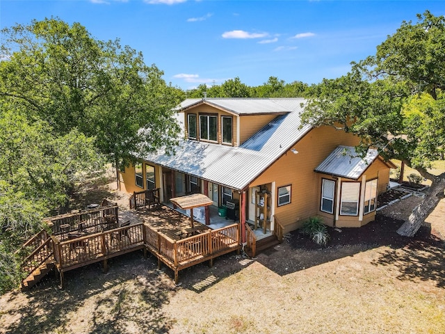 762 Karisch Rd, Giddings, TX 78942 - back of house featuring a metal roof, a deck, and view of wooded area