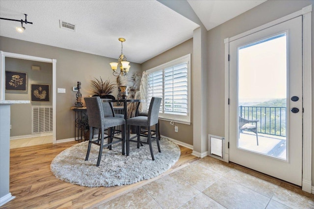 515 Wesley Ridge Dr, Spicewood, TX 78669 - dining room featuring a chandelier, wood finished floors, and a textured ceiling