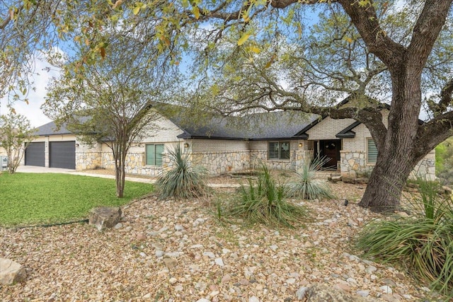 515 Wesley Ridge Dr, Spicewood, TX 78669 - view of front of home featuring stone siding, a front yard, driveway, roof with shingles, and an attached garage