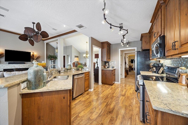 515 Wesley Ridge Dr, Spicewood, TX 78669 - kitchen featuring appliances with stainless steel finishes, a ceiling fan, open floor plan, light wood-style flooring, and tasteful backsplash