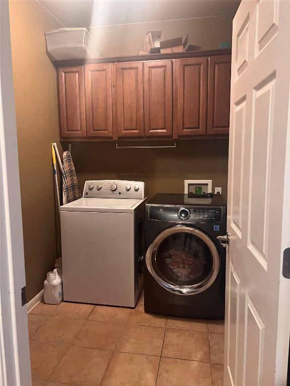 4522 Heritage Well Ln, Round Rock, TX 78665 - washroom featuring cabinet space, washing machine and dryer, and light tile patterned flooring