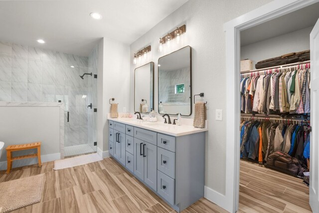 809 John Price, Blanco, TX 78606 - full bathroom with double vanity, a shower stall, a spacious closet, recessed lighting, and wood finished floors