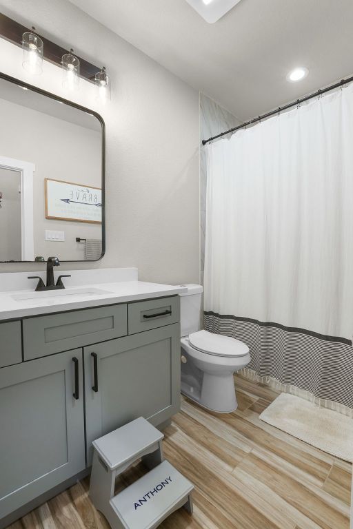 809 John Price, Blanco, TX 78606 - bathroom with vanity, wood finished floors, and a shower with curtain