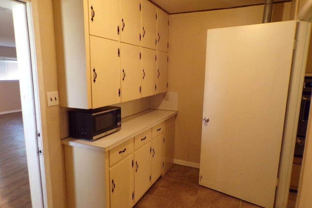 729 Yegua Dr, Lexington, TX 78947 - kitchen with black microwave, light countertops, white cabinets, and tile patterned flooring