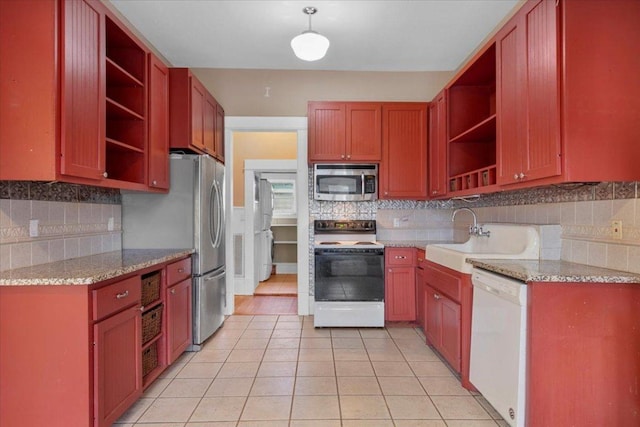 710 Gresham St, Smithville, TX 78957 - kitchen featuring appliances with stainless steel finishes, open shelves, tasteful backsplash, light tile patterned floors, and light stone counters