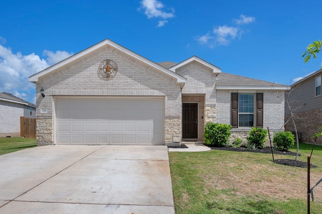 241 Pivot Dr, Taylor, TX 76574 - ranch-style home featuring driveway, an attached garage, brick siding, a front yard, and stone siding
