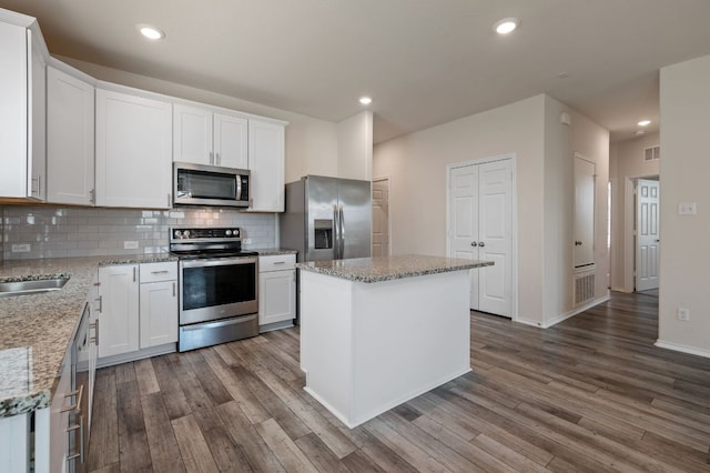 241 Pivot Dr, Taylor, TX 76574 - kitchen featuring appliances with stainless steel finishes, dark wood-style floors, decorative backsplash, white cabinets, and recessed lighting